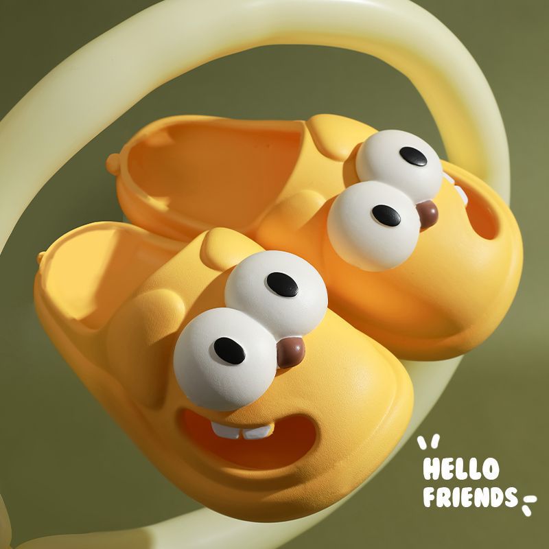 Yellow cartoonish shoes with googly eyes and a brown nose on a green background, featuring 'HELLO FRIENDS' text.
