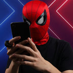 Person wearing a Spider-Man mask using a smartphone with a colorful background